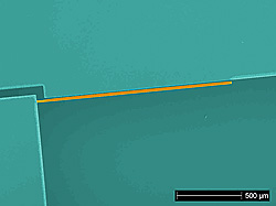 NIST physicists used radio waves to cool this silicon micro-cantilever, the narrow orange strip across the middle of this colorized micrograph. The cantilever, created by ion etching through a silicon wafer, lies parallel to a silicon radio-frequency electrode.

Credit: J. Britton/ NIST