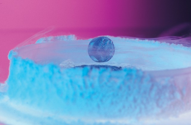 This photo shows a magnet levitating above a high-temperature superconductor, cooled with liquid nitrogen. A persistent electric current flows on the surface of the superconductor, effectively forming an electromagnet that repels the magnet. The expulsion of an electric field from a superconductor is known as the \"Meissner Effect.\"