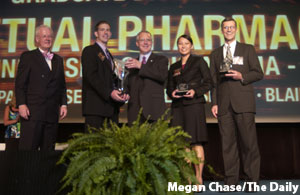 Price College graduate student Blaine Stansel (second left) receives the 1st place trophy for the Perpetual Pharmaceuticals group from Governor Brad Henry (center) Thursday evening at the Oklahoma Donald W. Reynolds Governors Cup Awards Dinner, held in Bricktown, Oklahoma City. On stage for the presentation, from left to right, is i2E CEO Greg Main, Blaine Stensel, Gov. Henry, Price College graduate student Pauline Stein, and advisor Lowell Busenitz. The Governors Cup is a tri-state competition for undergraduate and graduate college students that judges technology-baswed business startup plans.