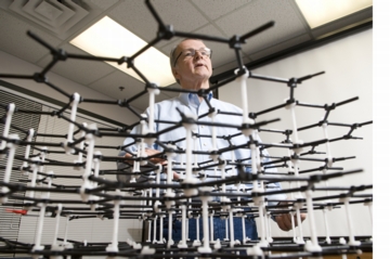 Drzal peers through a model of a carbon molecule. Photo by G.L. Kohuth.