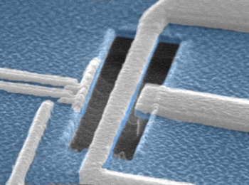 Scanning electron micrograph of a superconducting qubit in close proximity to a nanomechanical resonator. The nanoresonator is the bilayer (silicon nitride/aluminum) beam spanning the length of the trench in the center of the image; the qubit is the aluminum island located to the left of the nanoresonator. An aluminum electrode, located adjacent to the nanoresonator on the right, is used to actuate and sense the nanoresonator's motion.
[Credit: Electron beam lithography was performed by Richard Muller at JPL. Nanoresonator etch was performed by Junho Suh in the Roukes Lab. Image taken by Junho Suh.]