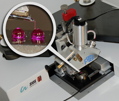 The micro probe used in the micro-nano CMM measures the form and the spacing of two reference spheres with diameters of two millimetres each. The figure shows a survey of the system and the proportions of measuring probe and measurement object in detail.