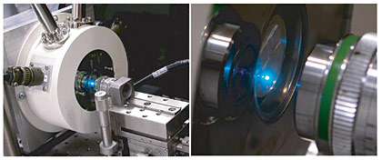 A bright point of light from a single plasmon laser emanates from the optical setup used by UC Berkeley researchers (enlarged closeup at right). These semiconductor lasers  the world's smallest  are extremely efficient, so the small amount of scattered light is clearly visible, even in ambient room lighting. Camera saturation of the bright laser light gives the impression of a larger spot. (Courtesy of Xiang Zhang Lab/UC Berkeley)