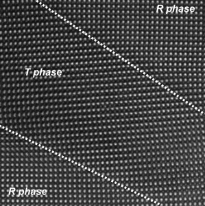 This high-resolution electron micrograph shows the the boundaries between rhombohedral (R phase) and tetragonal (T phase) regions  indicated by dashed lines - in a thin film of bismuth ferrite under epitaxial strain. A smooth transition between phases is observed with no dislocations or defects at the interface. The image was produced on TEAM 0.5 at the National Center for Electron Microscopy.