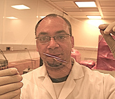 Doctoral student Lewis Gomez de Arco holds a plastic sheet with graphene layered on it.  Photo/Eric Mankin 