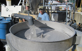 Clean water being passed over a vibratory separator after treatment with Osorb. Pictured are Dr. Stephen Jolly, ABSMaterials vice president for systems, and Doug Martin, ABSMaterials production manager. Credit: Sarah Pollock, ABSMaterials