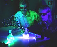 Professor Rainer Herges (left) and Marcel Dommaschk irradiate a solution of the molecular magnet switch with blue-green and blue-violet light. The researchers can change the magnetic state of the molecule using the light waves. Copyright: CAU, Photo: Torsten Winkler
