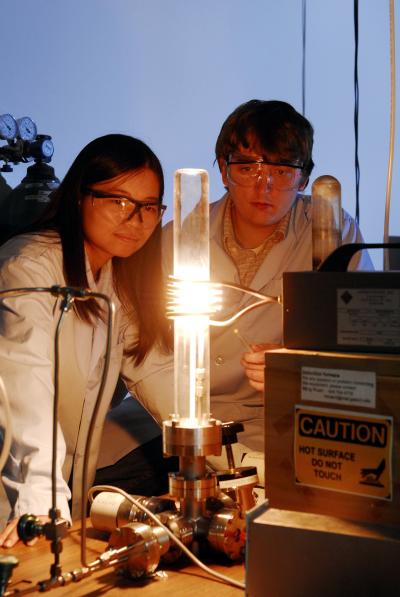 Georgia Tech graduate students Yike Hu and John Hankinson observe a high-temperature furnace used to produce epitaxial graphene on a silicon carbide wafer. A new "templated growth" technique allows fabrication of nanoribbons with smooth edges and high conductivity.

Credit: Georgia Tech Photo: Gary Meek