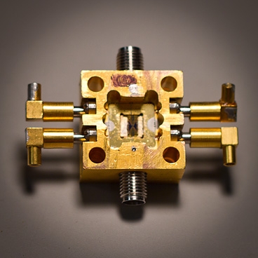 A superconducting circuit (small square, center) fits snugly into a housing that enables it to receive electrical signals inside a cooling tank.
Photo: Melanie Gonick