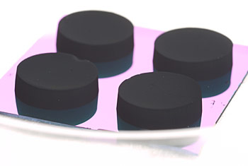 "Cupcakes" of vertically aligned carbon nanotube arrays (VANTAs) grown on silicon, which appears blue in the photo. A chunk of VANTA can be sliced from the silicon with a razor blade and, using the blade as a spatula, easily moved to the top of a laser power detector. The very dark nanotube coating absorbs terahertz laser light.
Credit: Lehman/NIST