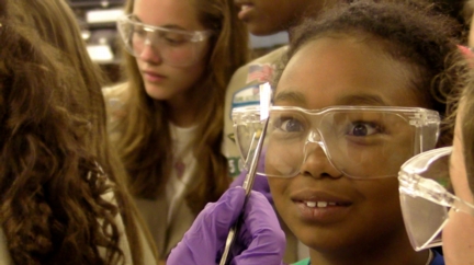 Members of Girl Scouts of America Troop 25080 of Houston look at fresh graphene, just out of the furnace and attached to a piece of copper. The troop visited a Rice University lab to watch researchers make graphene, a single-atom-thick sheet of carbon out of Girl Scout Cookies. (Credit: Rice University)
