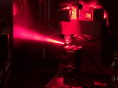 Near-field microscopy using the free electron laser at HZDR: An adjusting laser is employed to align the measuring tip of the microscope that comes from above. Below the movable sample stage is to be seen.