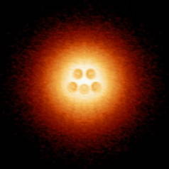An artificial atomic nucleus made up of five charged calcium dimers is centered in an atomic-collapse electron cloud. (Image courtesy of Michael Crommie)