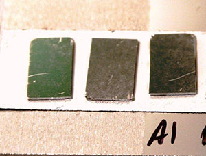 Black metal samples with different nanostructures thickness and coated with aluminum laying over a high reflective flat aluminum surface. 