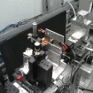 
The team's small prototype neutron microscope is shown set up for initial testing at MIT's Nuclear Reactor Laboratory. The microscope mirrors are inside the small metal box at top right.
Photo courtesy of the researchers 