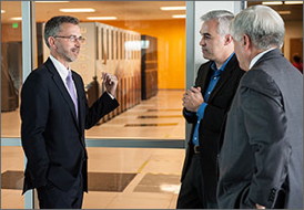 GSA Administrator Dan Tangherlini (left), NREL Associate Lab Director Bryan Hannegan, and NREL Director Dan Arvizu discuss the high performance computer Peregrine during a tour of the ESIF. NREL collaborated with HP and Intel to develop the innovative warm-water, liquid-cooled supercomputer, which recently won an R&D 100 award. Peregrine is the first installation of the HP Apollo 8000 platform, which uses more than 31,000 Intel Xeon processors providing a total compute capability of 1.19 petaflops.
Photo by Dennis Schroeder, NREL