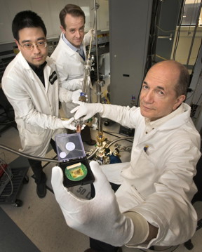 Jie Wu, Anthony Bollinger, and Ivan Bozovic (left to right) loading a sample in an apparatus capable of reaching a temperature one-third of a degree above absolute zero. The film held by Bozovic was made from a compound containing lanthanum, strontium, copper, and oxygen, and was grown with a continuous variation of chemical composition from one side to the other. The electrical resistivity of the resulting samples, each with a slightly different chemical composition, can be measured simultaneously.

(c) Brookhaven National Laboratory