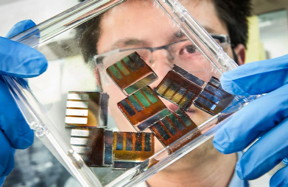 NREL researcher Mengjin Yang examines hybrid perovskite solar cells in his lab.Photo by Dennis Schroeder / NREL