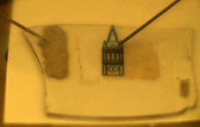 Gif of the device in action. Probes inject positive and negative charges in the light emitting device, which is transparent under the campanile outline, producing bright light.
CREDIT
Javey lab.