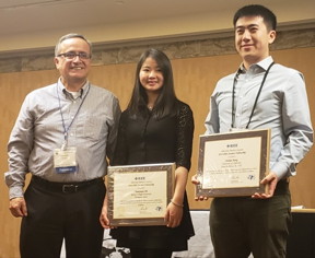 Junkai Jiang, right, receives his award from IEEE EDS president D. Fernando Guarin, left, along with fellow recipient Yuanyuan Shi, a doctoral student in Spain