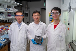 Rice University researchers  from left, Chuan Xia, Haotian Wang and Yang Xia  show a scaled-up hydrogen peroxide reactor that makes the valuable chemical using just air, water and electricity. Their work appears in the journal Science. (Credit: Brandon Martin/Rice University)

