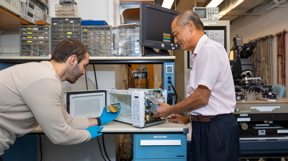Ryan Young/Cornell University
James Hwang, research professor in the Department of Materials Science and Engineering, right, at his modified microwave with Gianluca Fabi holding a semiconductor at left.