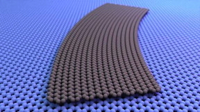A curved graphene ribbon, illustrated in grey, shown laid flat against another graphene sheet. There is a continuous change in the twist angle between the ribbon above and the sheet below. In some places the atomic lattices of the two sheets line up at a 0 angle to each other, while in others, they are twisted relative to each other by as much as 5.

CREDIT
Cory Dean, Columbia University