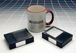 Picosatellites, less than one-half pound each, are shown against a coffee mug. The Aerospace Corporation.