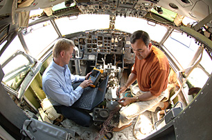 Mike Dinallo and Larry Schneider (left) prepare to employ the PASD diagnostic on a wiring bundle in the cockpit of a retired Boeing 737 at Sandias FAA Airworthiness Assurance NDI Validation Center. (Photo by Randy Montoya)