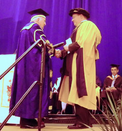 Neil Lewis (right) is pictured here receiving his Honorary Degree from the University Chancellor Lord Morris 