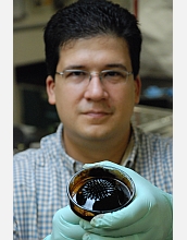Chemical engineer Carlos Rinaldi holds a beaker with oil based ferrofluid (a suspension of magnetic nanoparticles in an oil carrier fluid) with a permanent magnet underneath. The ferrofluid displays the so-called normal field instability, characterized by spikes of fluid following the local magnetic field direction. Rinaldi's work has importance for applications in nanobiosensors and in magnetic fluid hyperthermia for cancer treatment.

Credit: Sindia M. Rivera-Jimnez