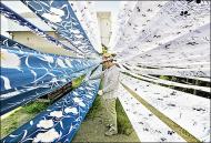 A craftsman spreads his fabric out to dry