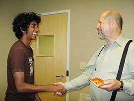 New NanoExplorer Anish Jacob shares pizza and a handshake with Dr. Ray Baughman, who founded the NanoExplorers program.