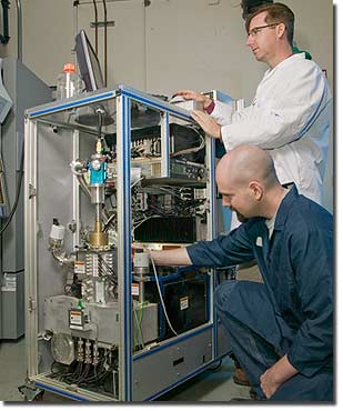 Photos by Jacqueline McBride
Physicist Paul Steele (kneeling) and chemist Keith Coffee make adjustments to the LLNL detection instrument known as Single-Particle Aerosol Mass Spectrometry, or SPAMS.
