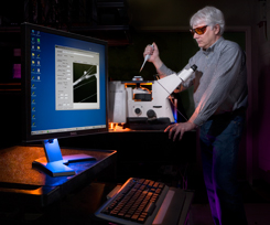 Sandia researcher Carl Hayden positions a sample on the spectrally resolved, confocal imaging microscope.
