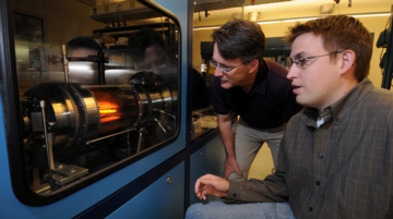 Timothy D. Sands, at left, director of Purdue's Birck Nanotechnology Center in Discovery Park, and graduate student Mark Oliver, operate a "reactor" in work aimed at perfecting solid-state lighting, a technology that could cut electricity consumption by 10 percent if widely adopted. Inside the reactor, a material called gallium nitride is deposited on silicon at  temperatures of about 1,000 degrees Celsius, or 1,800 degrees Fahrenheit. Purdue researchers have overcome a major obstacle in reducing the cost of the lighting technology, called light-emitting diodes . (Purdue News Service photo/David Umberger)