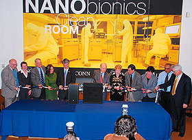 Legislators and other dignitaries join University President Michael Hogan, center, and Gov. M. Jodi Rell, fifth from right, for a ribbon-cutting at the nanobionics clean room on Oct. 20. From left are Prof. Harris Marcus, Mary Ann Hanley, former U.S. Rep. Rob Simmons, State Rep. Denise Merrill, State Sens. Donald E. Williams Jr., Gary LeBeau, and Eileen Daily, Vinod Makhijani, and Higher Education Commissioner Michael Meotti. Photo by Gerald Ling