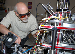 NIST researcher Jabez McClelland makes adjustments on the new magneto-optical trap ion source, capable of focusing beams of ions down to nanometer spots for use as a 'nano-scalpel' in advanced electronics processing.

Credit: Holmes, NIST