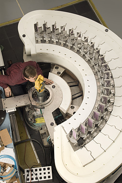 Top view of the MACS multiaxis detector system (seen before being enclosed in shielding material). With more neutrons striking the sample and more detectors surrounding it, MACS will greatly extend the capabilities of neutron inelastic scattering as a materials probe technique in nanotechnology and basic science. Principal investigator Collin Broholm of the Johns Hopkins University is seen examining the alignment of one of the 20 detection channels.

Copyright: Robert Rathe