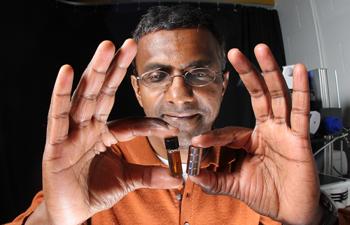 Purdue professor Joseph Irudayaraj uses a magnet to attract tiny magnetic particles in a solution. Irudayaraj designed nanoprobes with gold and magnetic particles that could be used to deliver drugs directly to cancer cells. (Purdue Agricultural Communication photo/Tom Campbell)