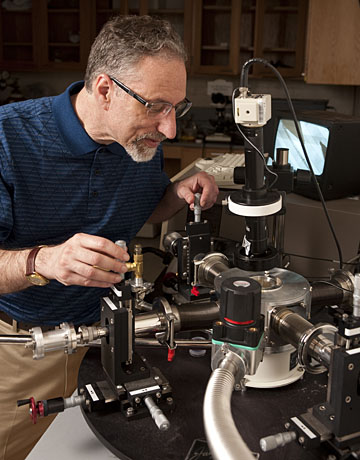 In his Johns Hopkins materials science lab, Howard E. Katz adjusts probes used for testing electronic devices. Photo by Will Kirk, Homewoodphoto.jhu.edu.
