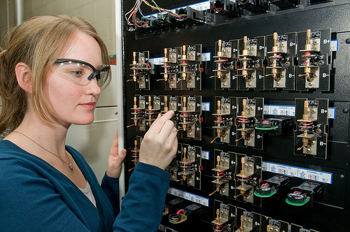 Argonne researcher Lynn Trahey loads a coin-sized cell on a testing unit used to evaluate electrochemical cycling performance in batteries. Photo by Wes Agresta / Courtesy Argonne National Laboratory.