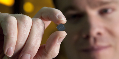 BYU prof Aaron Hawkins holds a tiny microchip that can detect viruses in fluid.