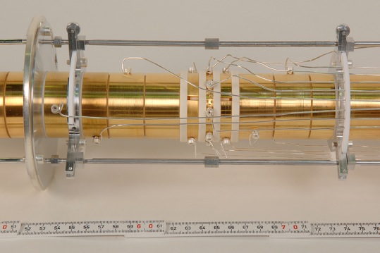 The picture shows the Penning trap, which is part of the Shiptrap experiment. A magnetic field parallel to the tube forces the arriving ions onto a spiral course inside the tube. The ions spiraling frequency is used to directly calculate their atomic mass.