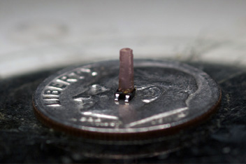 A magnetic crystal sits on the head of a dime for scale. Scientists exploit the randomness of the magnetic field in the crystal at the molecular level to control the properties of the magnet as a whole. The chip underneath the crystal is a magnetic sensor.