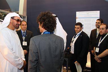 Dr. Matteo Chiesa (foreground) and Asylum Researchs Mick Phillips (right) discuss AFM solar energy applications with visitors to the MASDAR LENS booth, including His Highness General Sheikh Mohamed bin Zayed Al Nahyan, Crown Prince of Abu Dhabi (left).