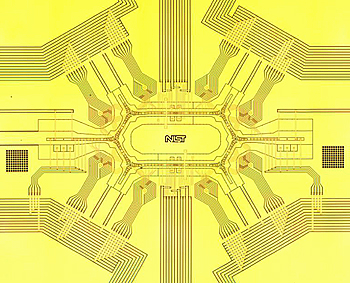 Photograph of NIST racetrack ion trap under development as possible hardware for a future quantum computer. The 150 zones for storing, transporting and probing ions (electrically charged atoms) are located in the center ring structure and the six channels radiating out from its edges. Credit: J. Amini/NIST