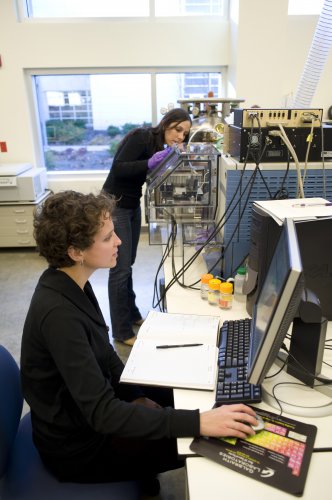 Bindley Bioscience Center researchers Allison Dill, in foreground, and Livia Eberlin analyze molecular fingerprint signatures gathered from a miniature mass spectrometer combined with a technique called desorption electrospray ionization, known as DESI. The device and technique, developed by team led by Purdue professor R. Graham Cooks, will be an essential research tool for the planned Multidisciplinary Cancer Research Facility. (Purdue University photo/Vincent Walter)