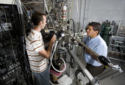 Purdue nuclear engineering doctoral student Chase Taylor, at left, and Jean Paul Allain, an assistant professor of nuclear engineering, are using this facility in work aimed at developing coatings capable of withstanding the grueling conditions inside nuclear fusion reactors. The research focuses on the "plasma-material interface," a crucial region where the inner lining of a fusion reactor comes into contact with the extreme heat of the plasma. (Purdue University photo/Mark Simons)