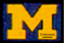 An optical microscopy image of a 12-by-9-micron U-M logo produced with this new color filter process. The image is a bit blurry because it has been magnified about 5,000 times. Credit: Jay Guo. 